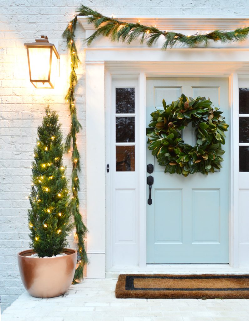 Close Up Of Front Porch With Painted Blue Door Decorated For Christmas