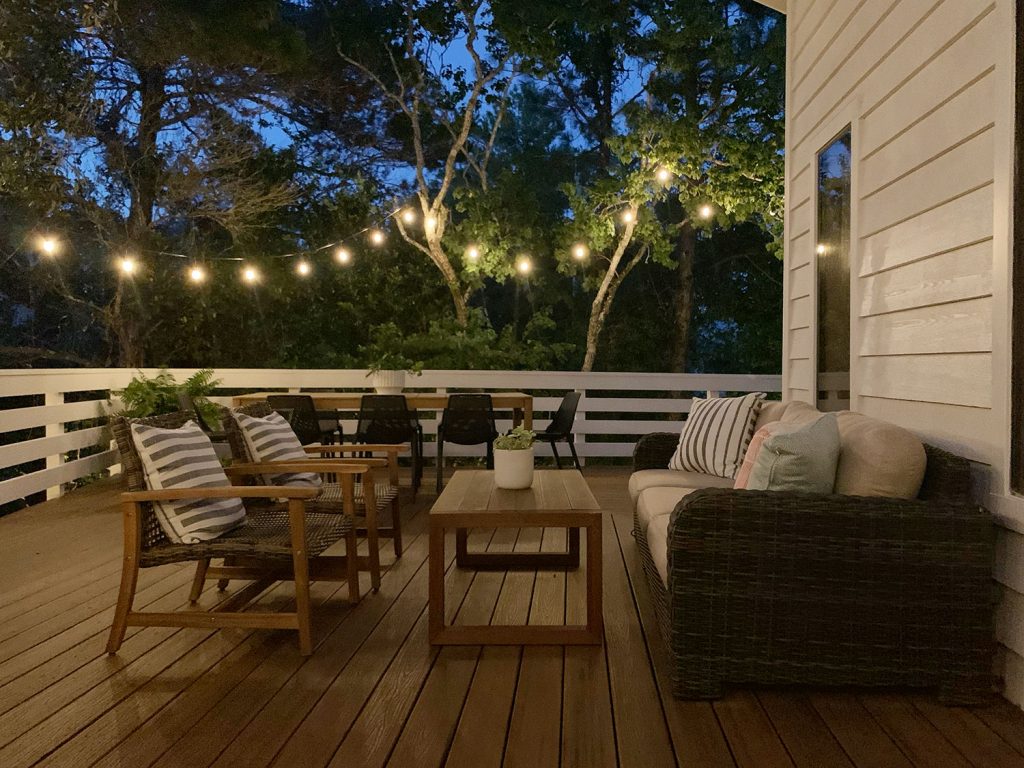 Nighttime View Of Outdoor Deck Seating Area With String Lights
