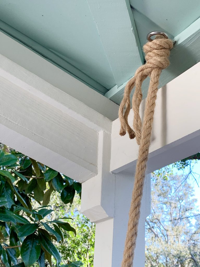 Rope knotted around screw eye hook in ceiling of covered porch