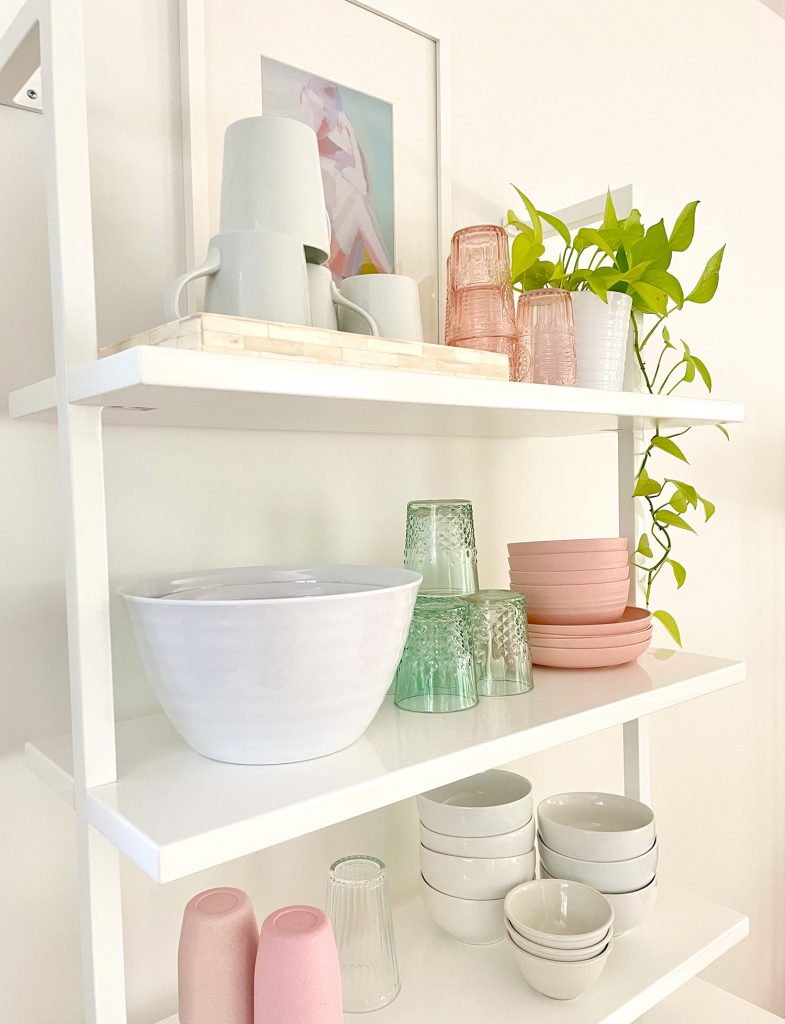 Detail View Of CB2 Floating Ladder Bookcase With Kitchenware On It