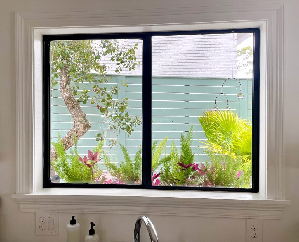 View Through Kitchen Window With Window Box And Tropical Plants