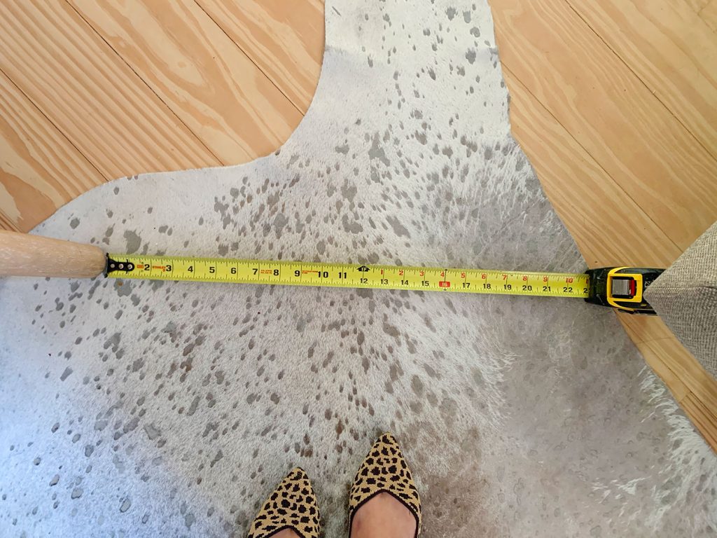 Measuring tape showing walking space between pieces of furniture in sitting area