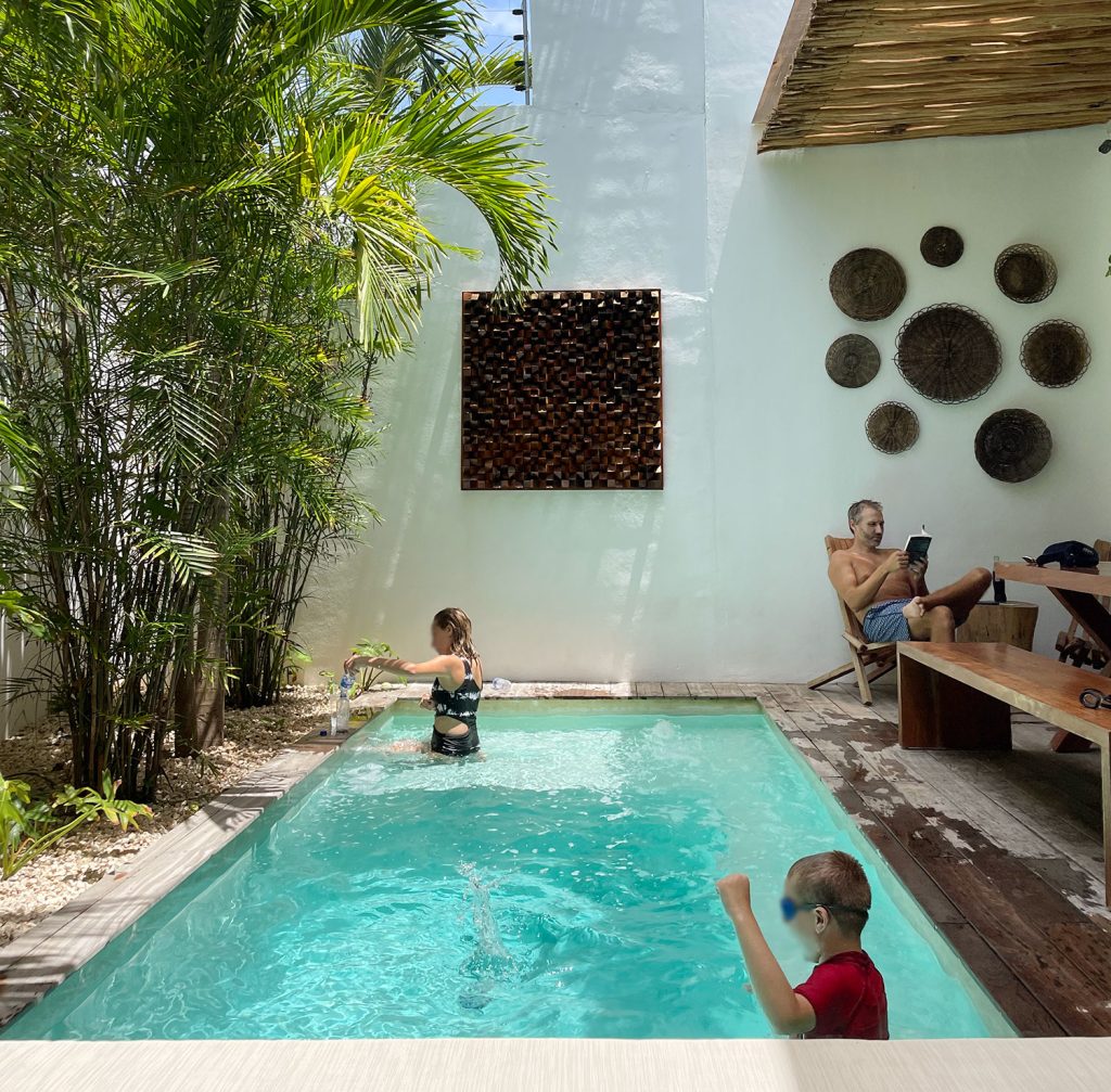 Kids Playing John Reading At Airbnb Pool In Tulum Mexico