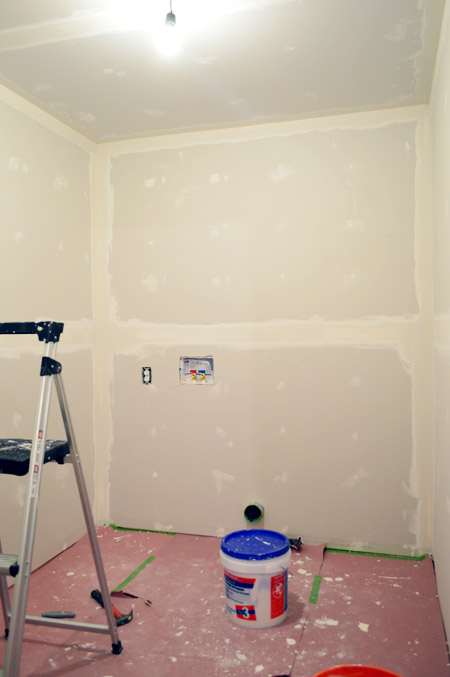 small room with one coat of drywall tape and mud applied
